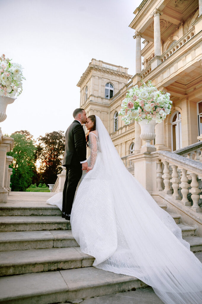 mariage-chateau-de-ferrieres-couple-s-embrassant-escalier-voile-mariee.jpg